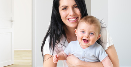 A young woman holding a baby